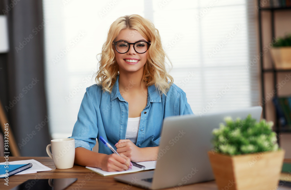 快乐的年轻商务女性在家办公，在电脑上工作