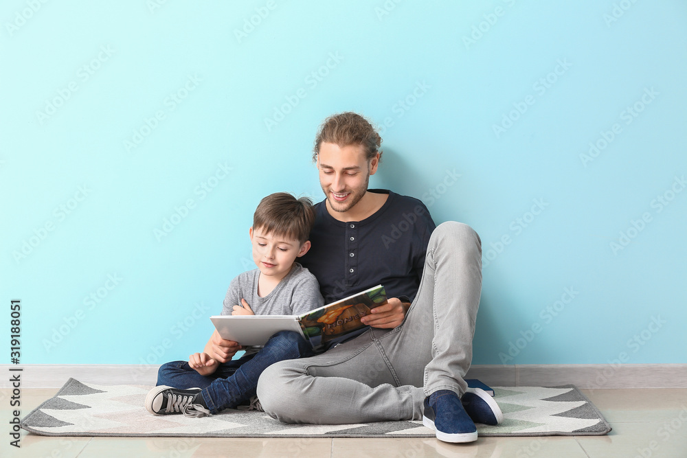 父亲和他的小儿子在光墙附近看书