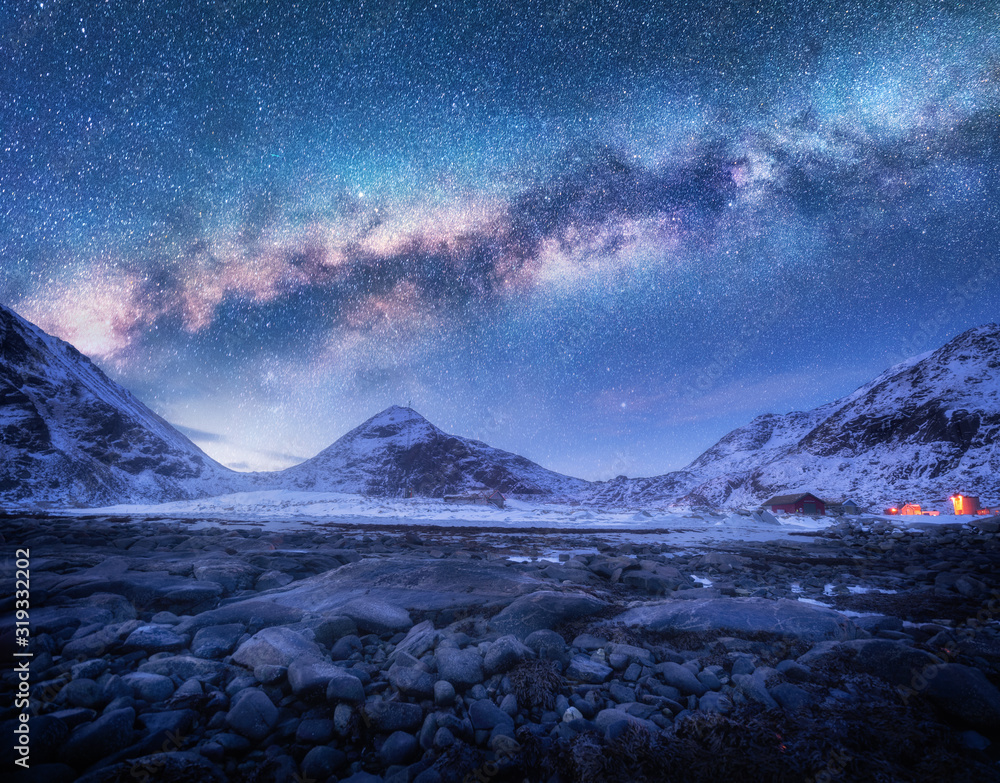 诺华罗弗敦群岛冬季夜晚白雪覆盖的山脉和石头海滩上的银河