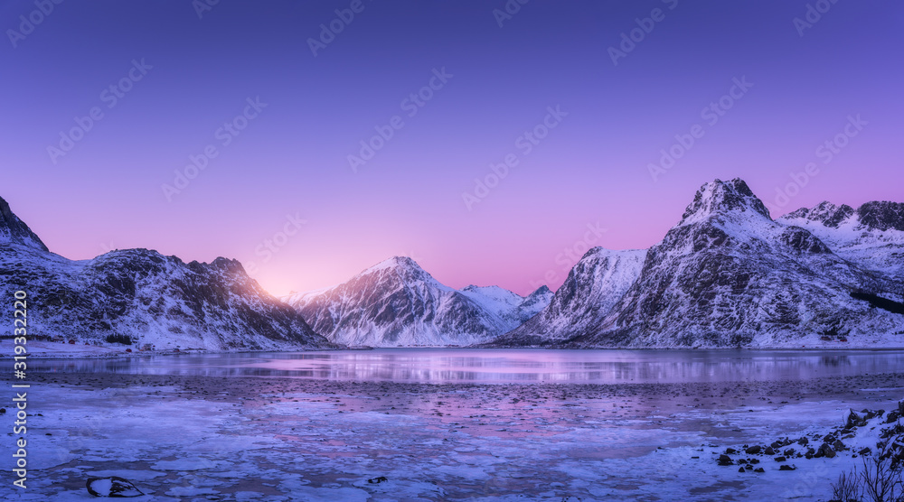 雪山，蓝色的大海，结霜的海岸，水中的倒影，彩色日落时的紫色天空