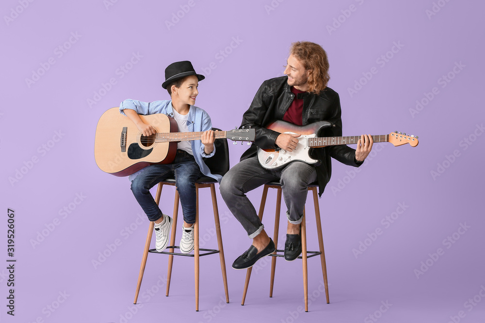 男人和他的小儿子在彩色背景下弹吉他