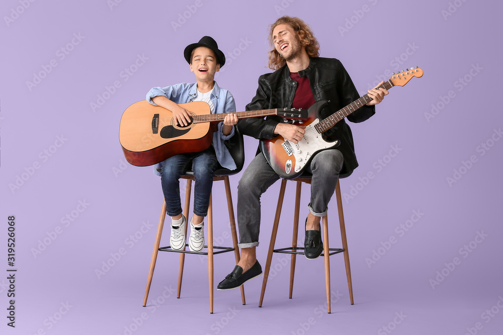 男人和他的小儿子在彩色背景下弹吉他