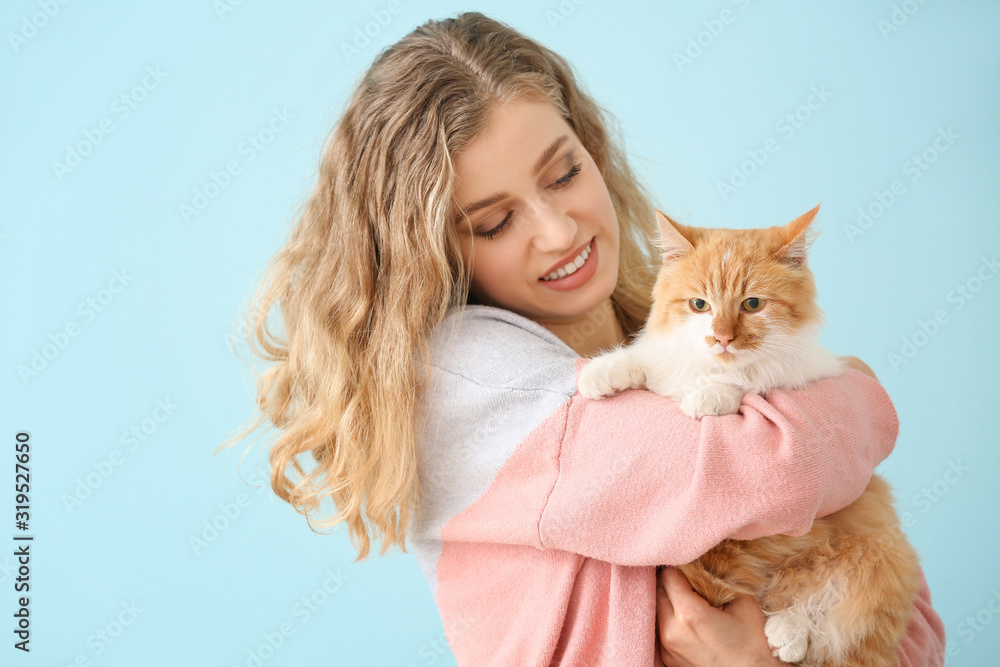 美丽的年轻女人，彩色背景上有可爱的猫