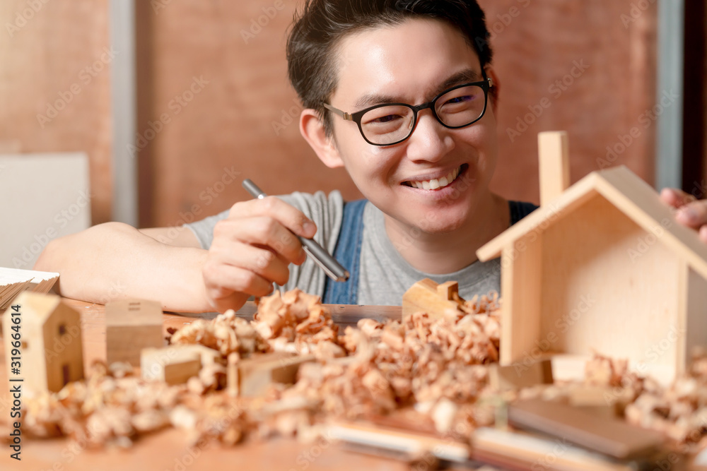 聪明迷人的轻便眼镜亚洲男性手工艺者或室内设计师专注于c场地的木材工作
