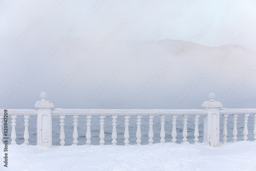 冬天湖岸上霜冻和结冰的栏杆。俄罗斯西伯利亚利斯特维扬卡贝加尔湖。