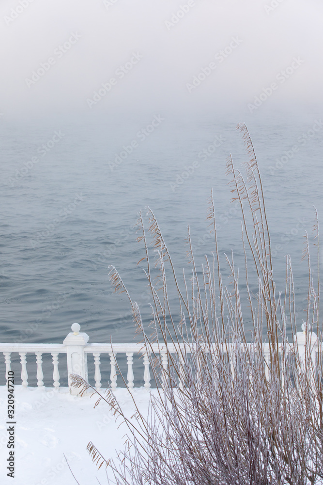 冬天湖岸上霜冻和结冰的栏杆。俄罗斯西伯利亚利斯特维扬卡贝加尔湖。
