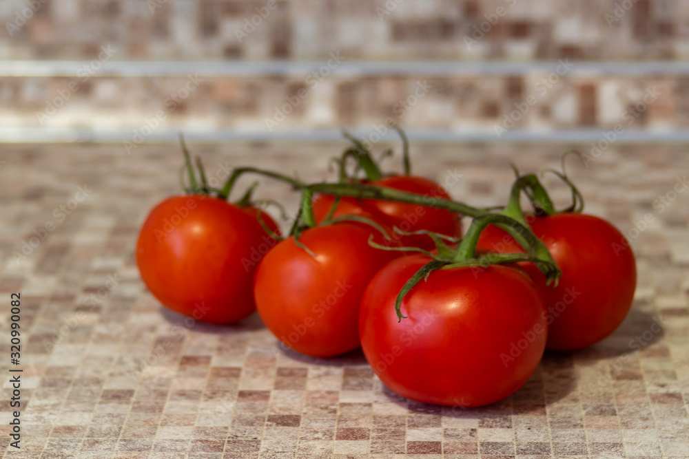 石桌上成熟的红番茄的枝条。番茄是许多菜肴和酱汁的蔬菜基质