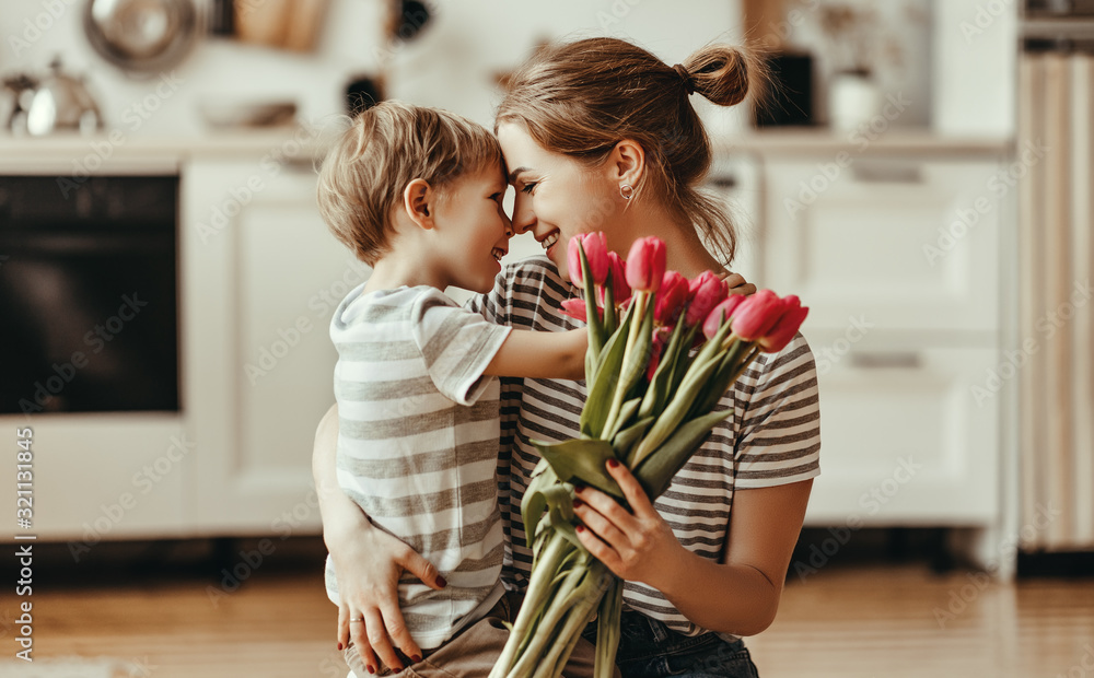happy mothers day! child son gives flowers for  mother on holiday .