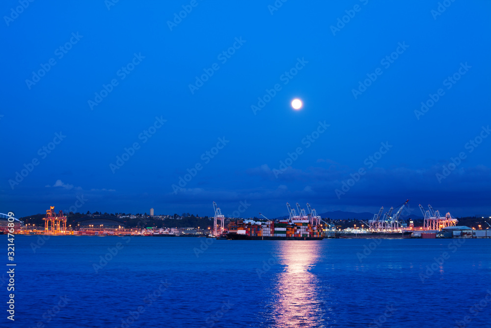 Big lune with trail on water of Elliot bay over Seattle port night view, WA, USA
