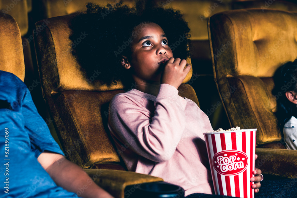 三个孩子玩得很开心，喜欢在电影院看电影