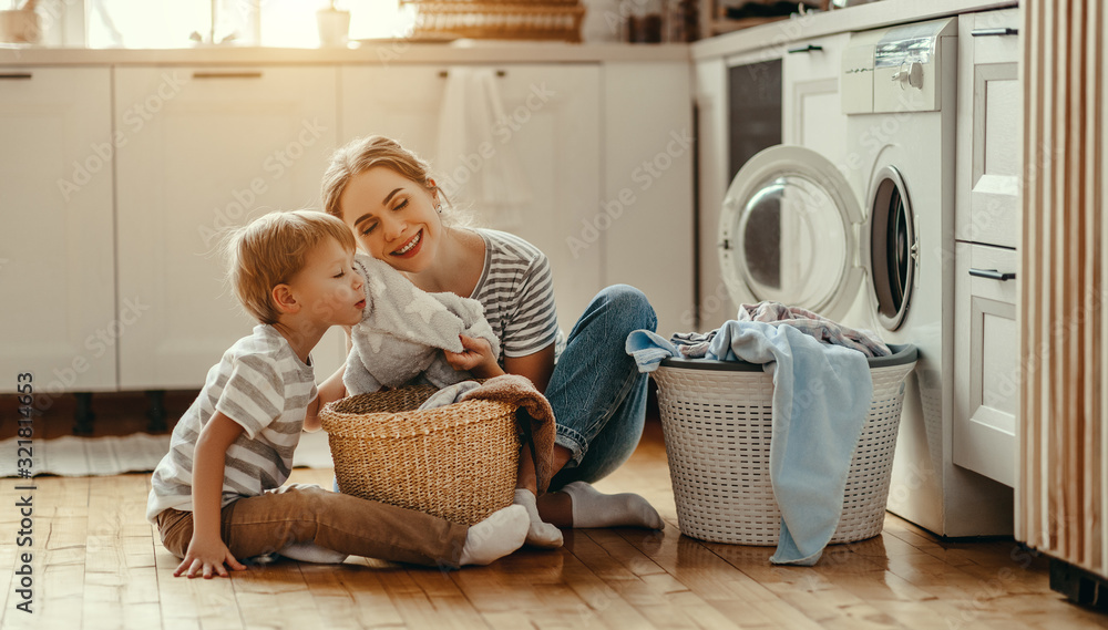 幸福的家庭主妇和孩子在洗衣机里。