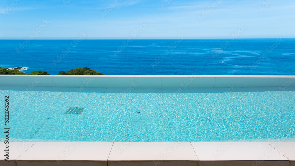 Swimming pool overlooking view andaman sea and clear sky background,summer holiday background concep