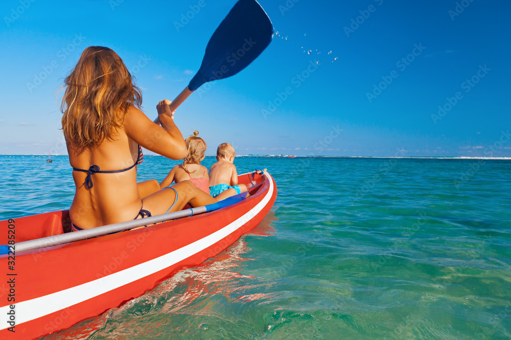 幸福的家庭-年轻的母亲，孩子们在划船时玩得很开心。女人和孩子们在皮划艇上划水。Trav