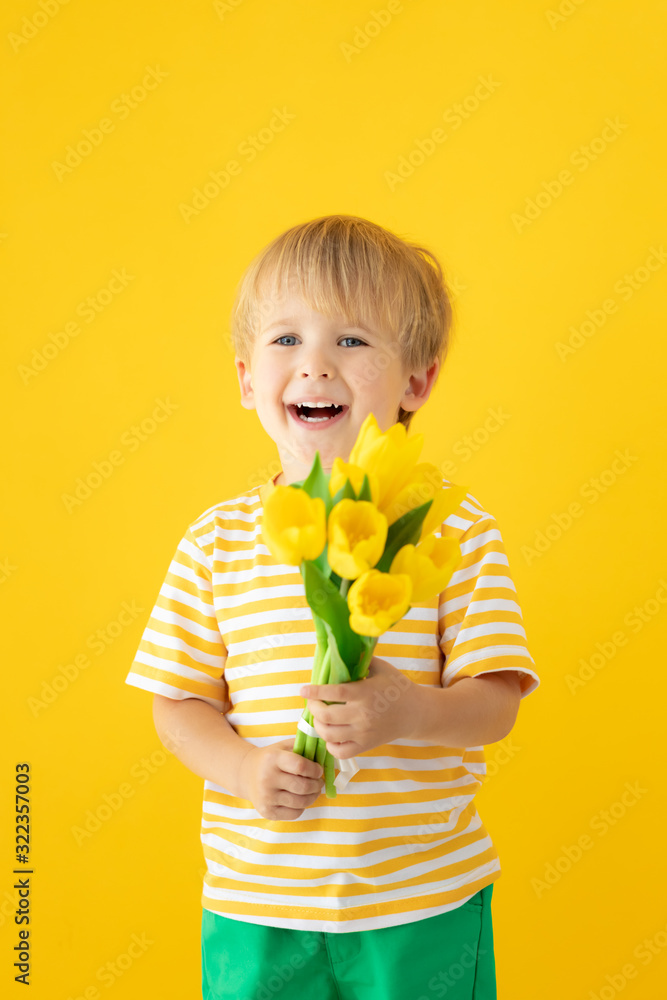 Happy child holding spring bouquet of flowers