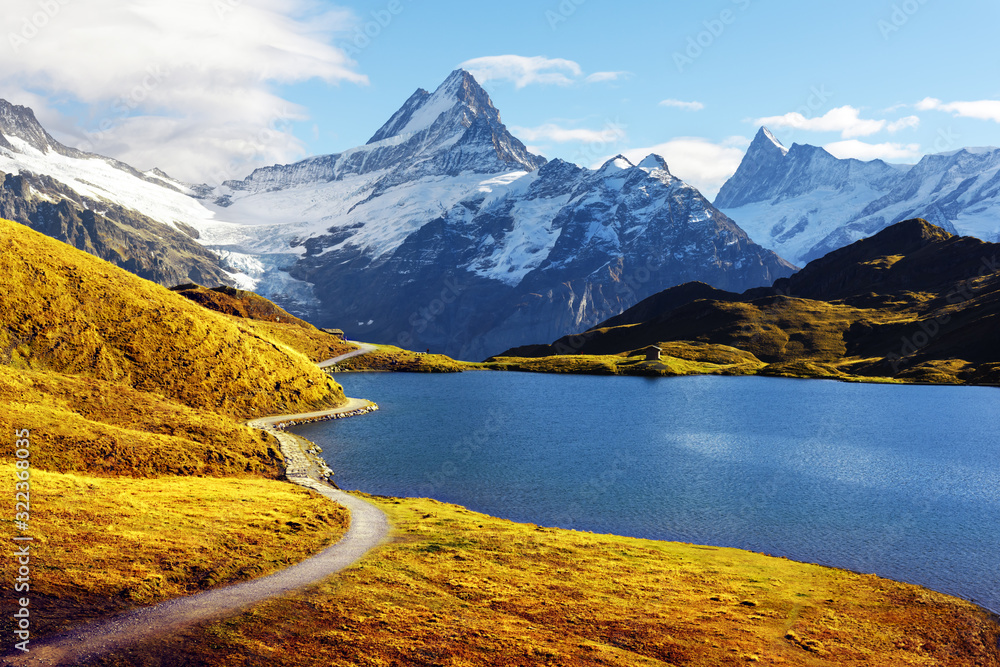 Picturesque view on Bachalpsee lake in Swiss Alps mountains. Snowy peaks of Wetterhorn, Mittelhorn a