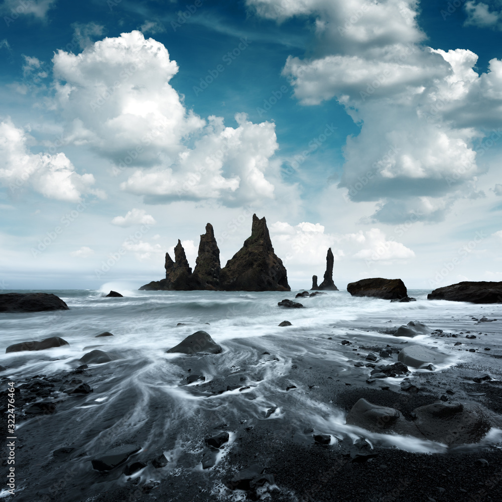 Picturesque landscape with basalt rock formations Troll Toes on Black beach, stormy ocean waves and 