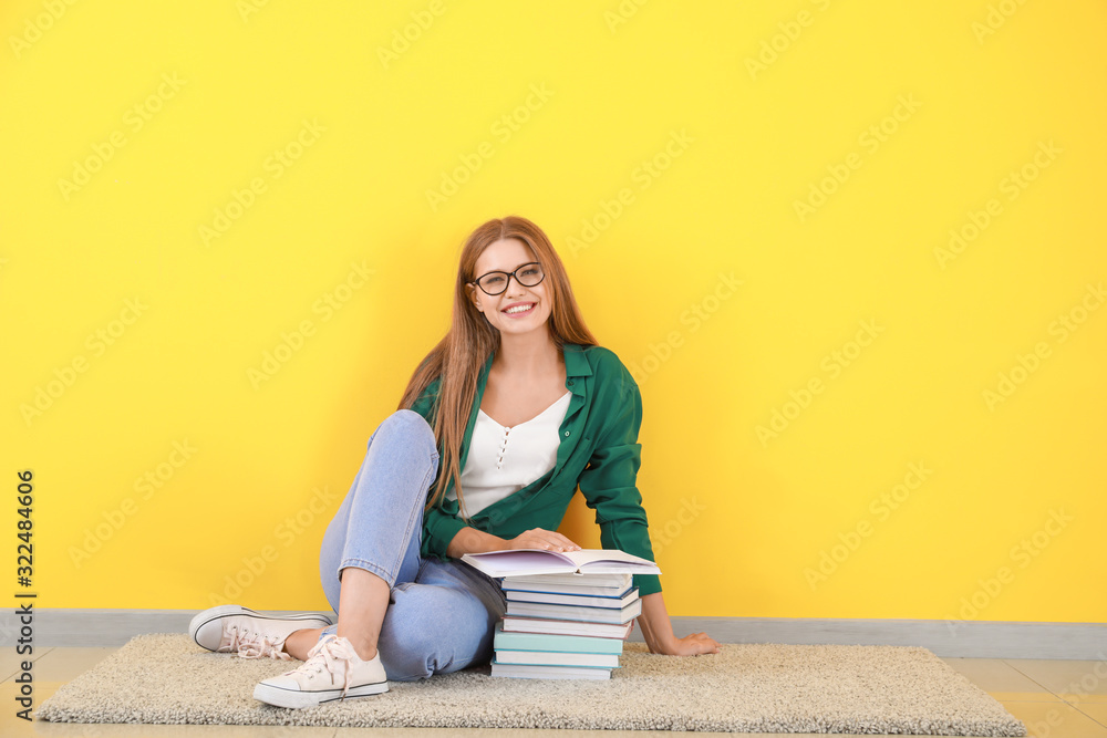 坐在彩色墙附近看书的年轻女人