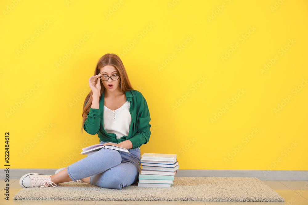 坐在彩色墙上的书让一位年轻女士大吃一惊