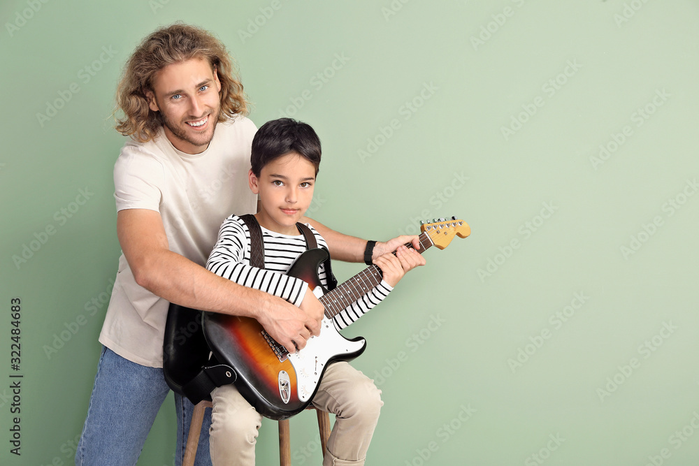 一名男子在彩色背景下教儿子弹吉他