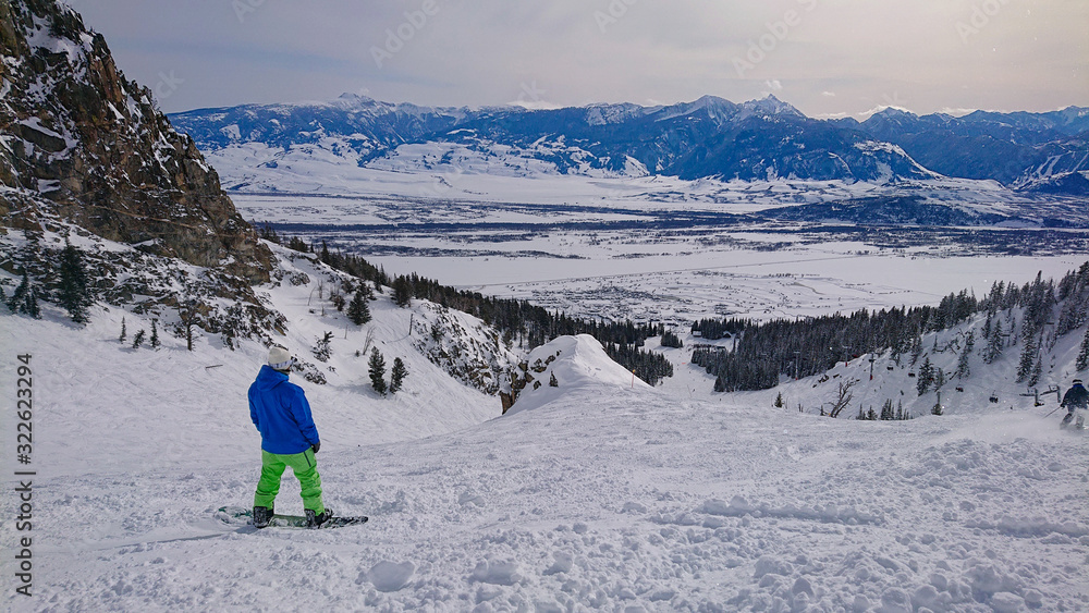 滑雪运动员在滑雪场斜坡上骑行前观察雪景