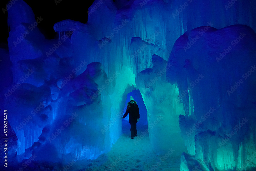 一名年轻女子在科罗拉多州一个壮观的布满冰柱的冰洞里走来走去。