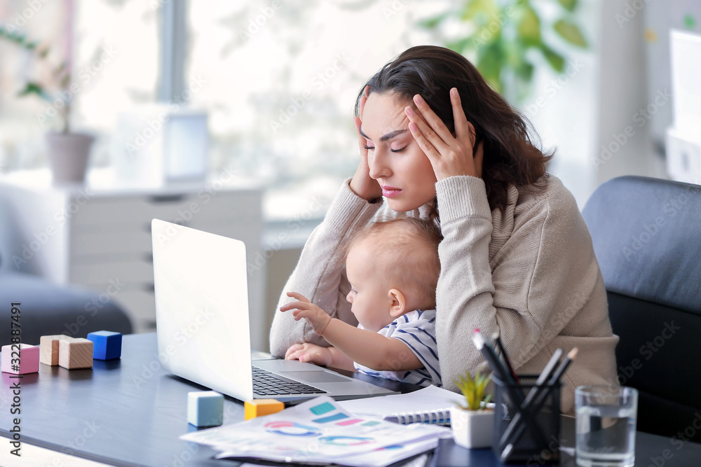 带着孩子在办公室工作的压力重重的母亲