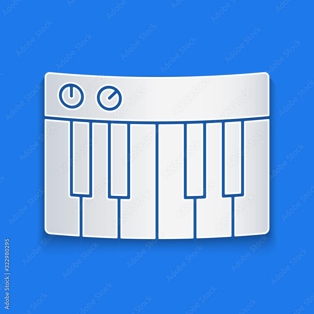 蓝色背景上隔离的剪纸音乐合成器图标。电子钢琴。纸艺风格。Vec