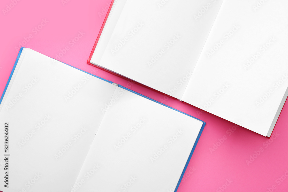 Two open books on color background