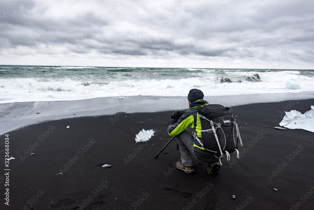 摄影师在冰岛Jokulsarlon泻湖附近的钻石海滩上拍照。风景摄影