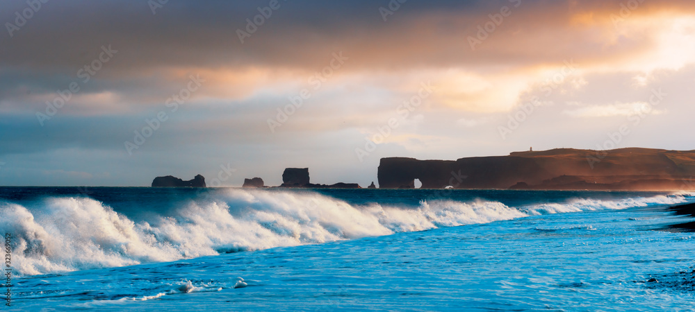 Gorgeous panorama landscape with large waves on Black beach. Stormy Atlantic ocean waves and cloudsc