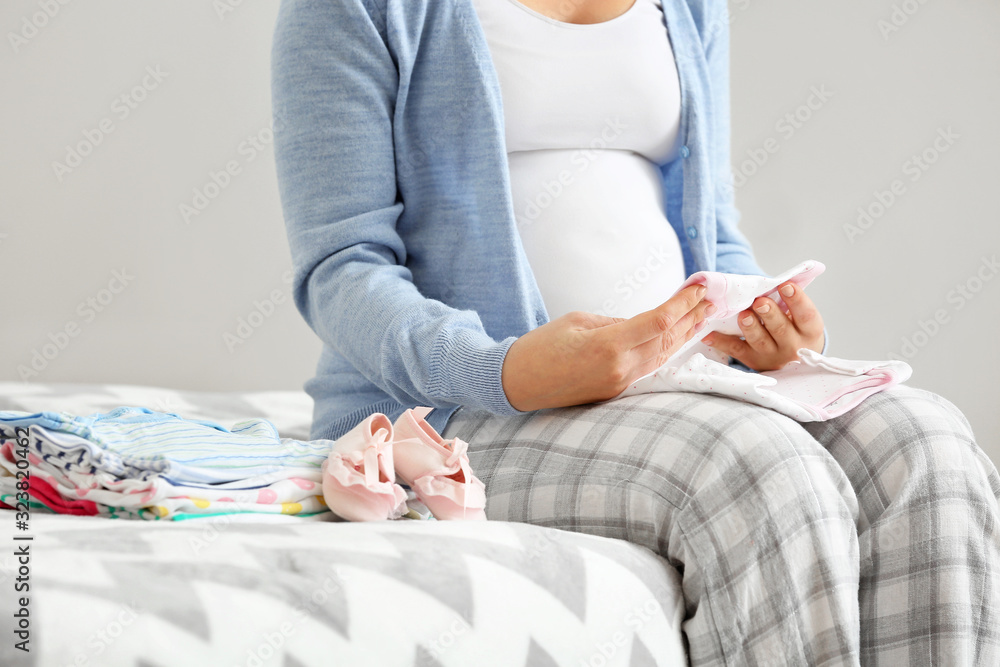 孕妇卧室里有婴儿衣服，特写