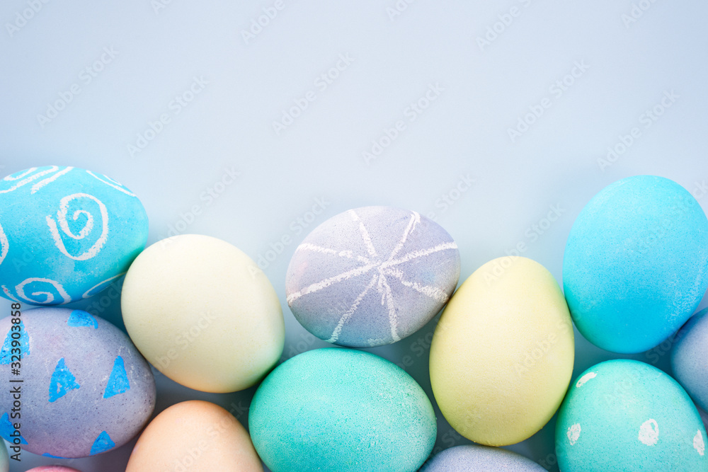 Colorful Easter eggs dyed by colored water with beautiful pattern on a pale blue background, design 
