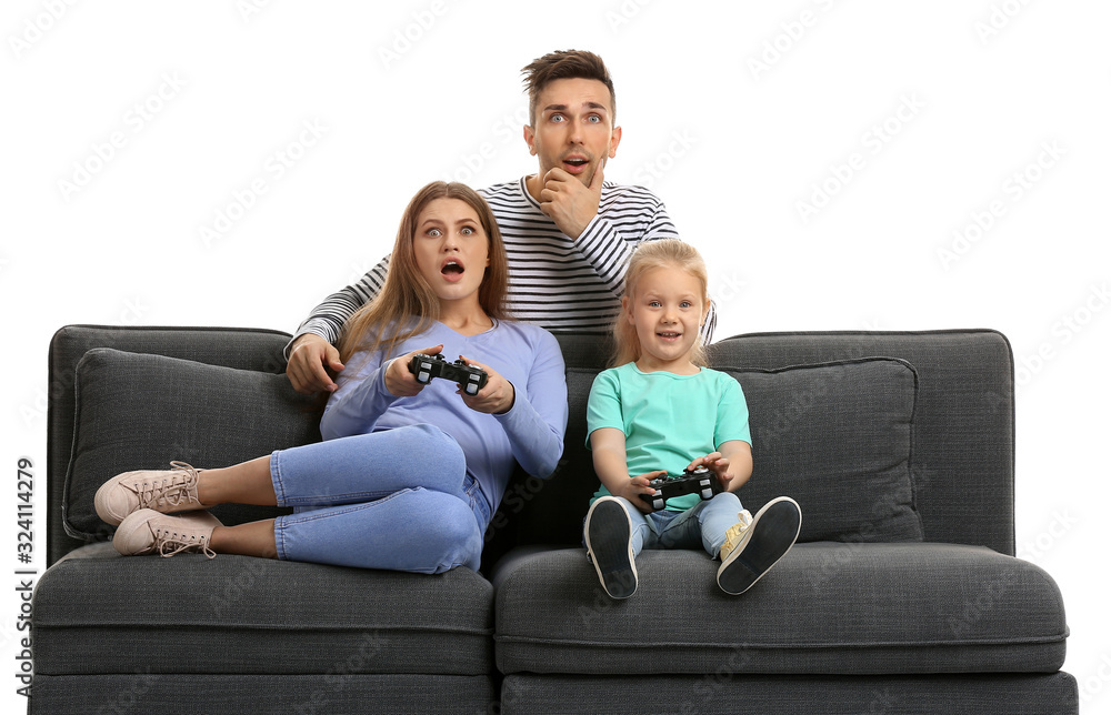 Young family playing video games while sitting on sofa against white background