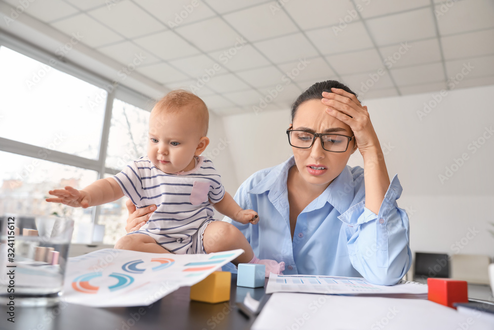 Stressed mother with her baby working in office