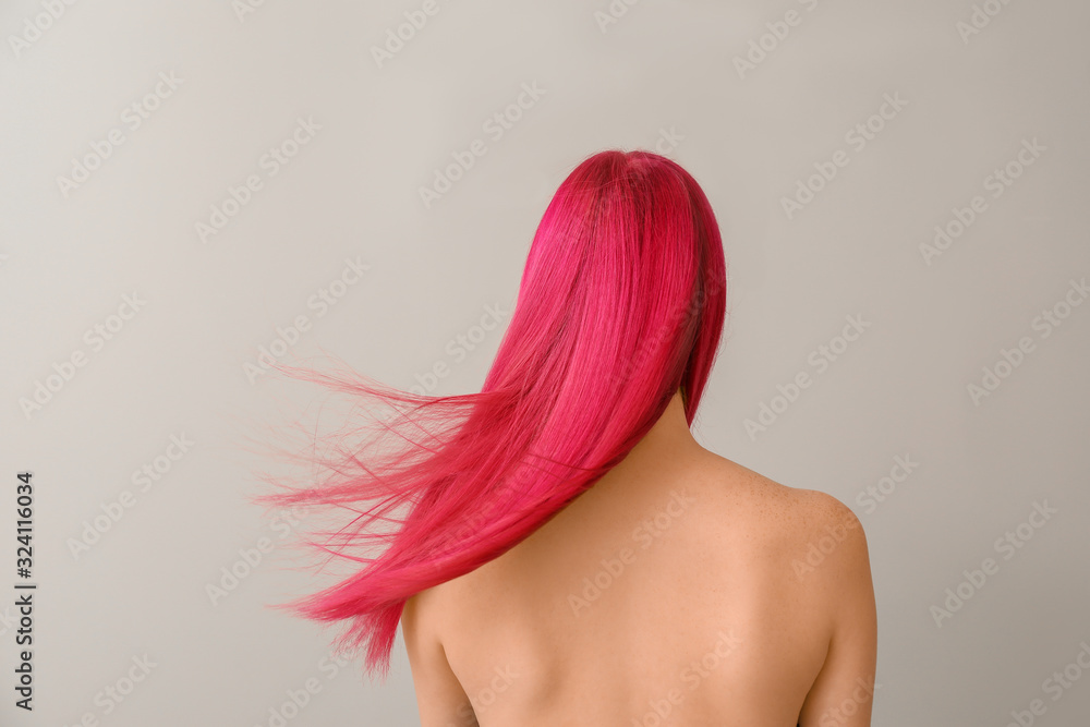 Beautiful young woman with unusual hair color on light background