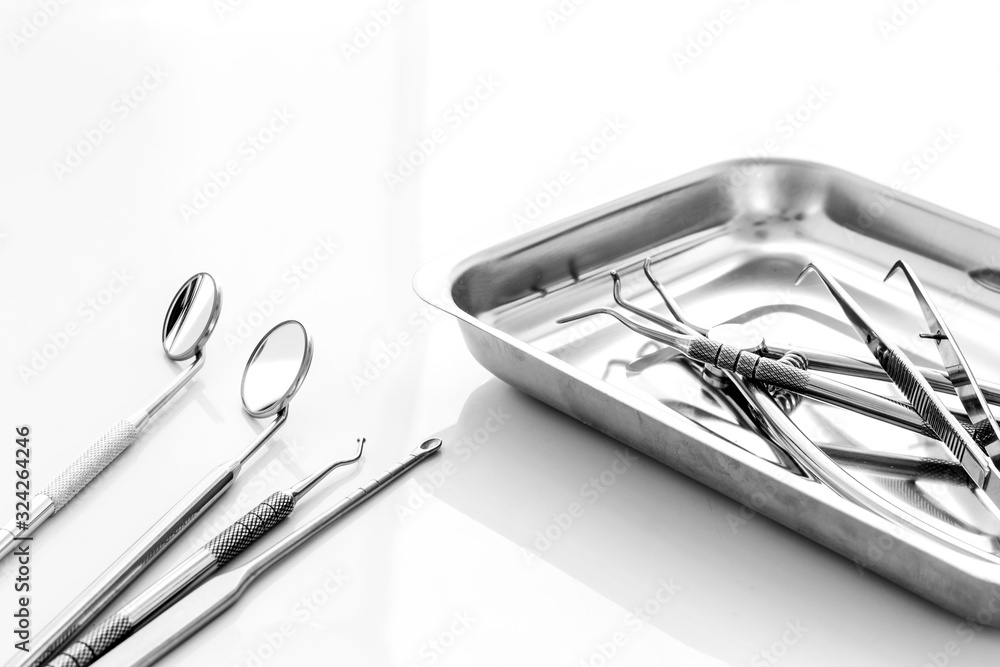 Dental instruments in stainless steel tray on white background close up space for text