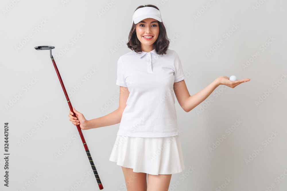 浅色背景下美丽的女高尔夫球手