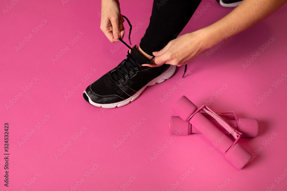 粉色背景系运动鞋的女人