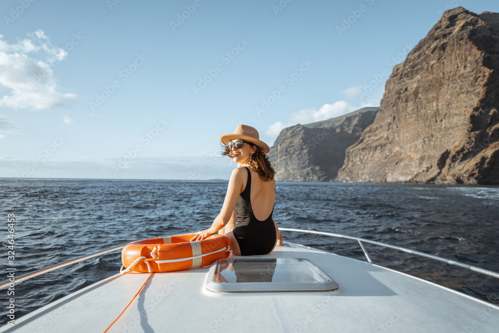 一名女子在呼吸附近航行时，将救生圈放在游艇机头上，享受海上航行