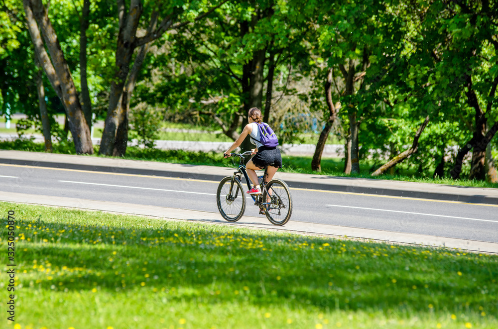 骑自行车的人在城市公园的自行车道上骑行