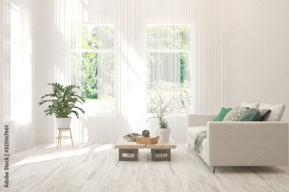 白色极简主义客厅，窗户里有沙发和夏季景观。斯堪的纳维亚室内