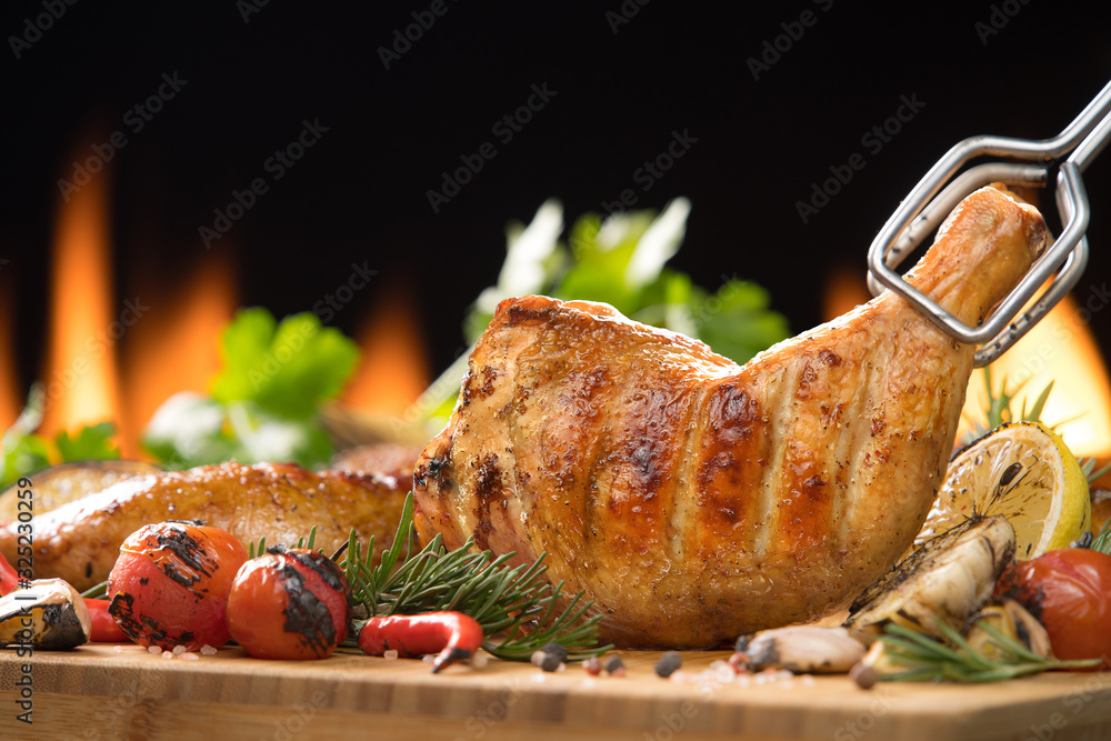 Grilled chicken thigh with various vegetables on  chopping wood
