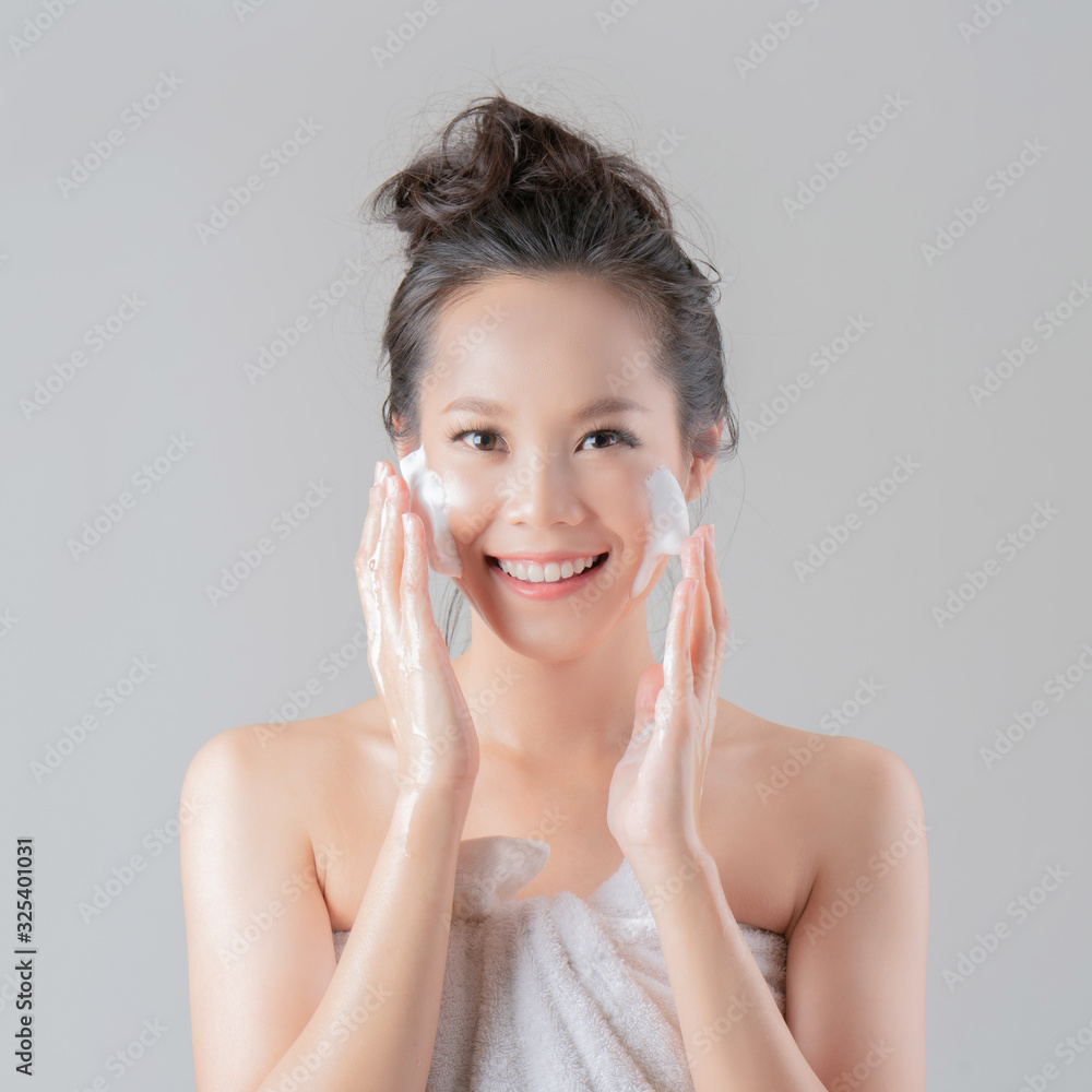 亚洲女性将使用面部泡沫来洗掉脸上的化妆品。白皙的背部