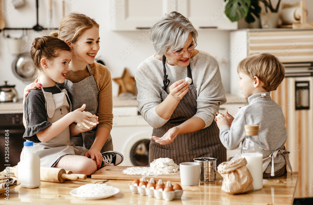 幸福的家庭一位祖母带着她的女儿和孙子在厨房做饭、揉面团、烤面包