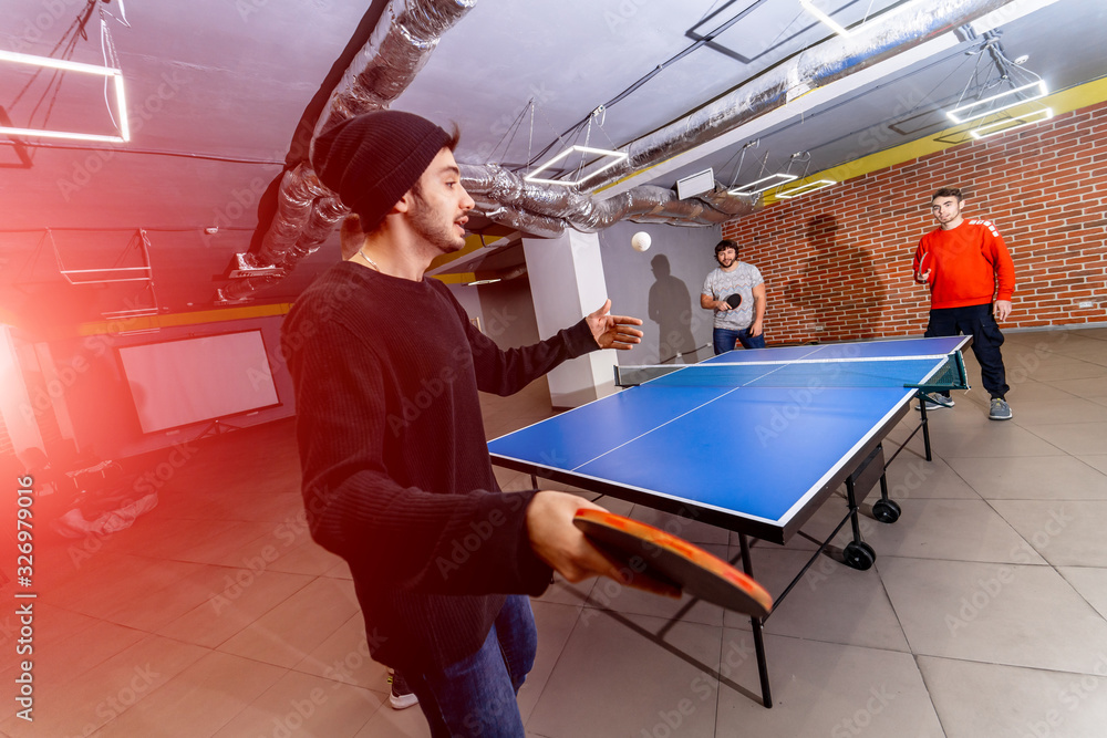 一群快乐的年轻朋友在办公室或任何房间打乒乓球。健康概念