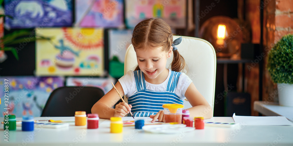 有趣的小女孩用颜料画出笑声。