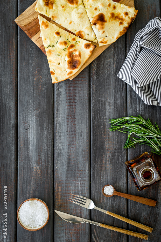 Italian focaccia with cheese and rosemary on dark wooden background top-down copy space
