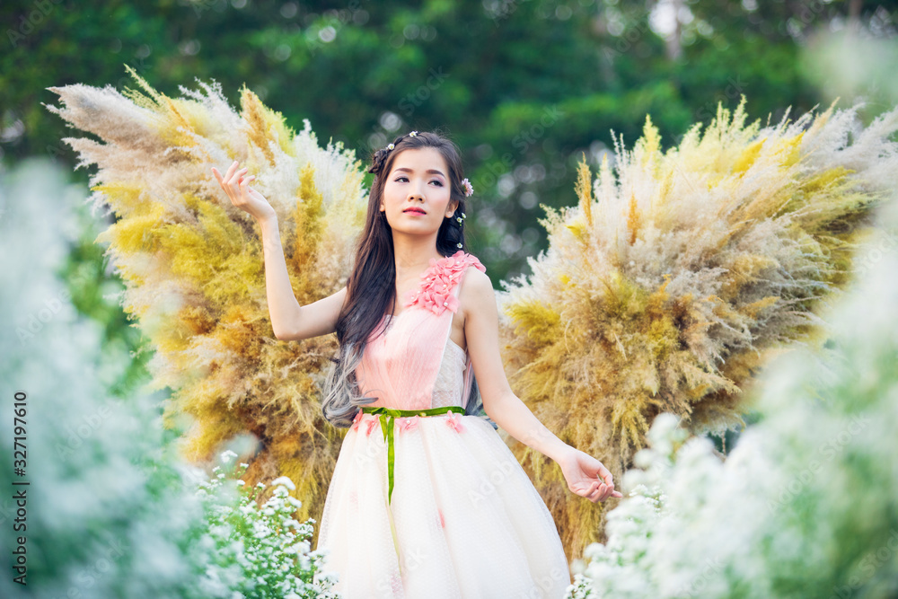 beautiful girl with angel wings,Beautiful angel standing  in the flower garden,Portrait of a young, 