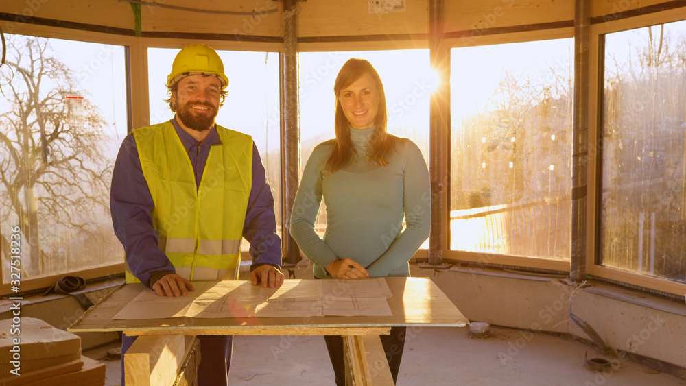 肖像：建筑师和房地产投资者在讨论平面图后微笑。