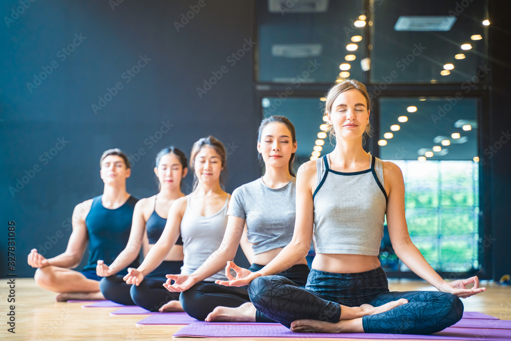 一群多元道德的人在健身俱乐部学习瑜伽课。高加索女教练领军人物